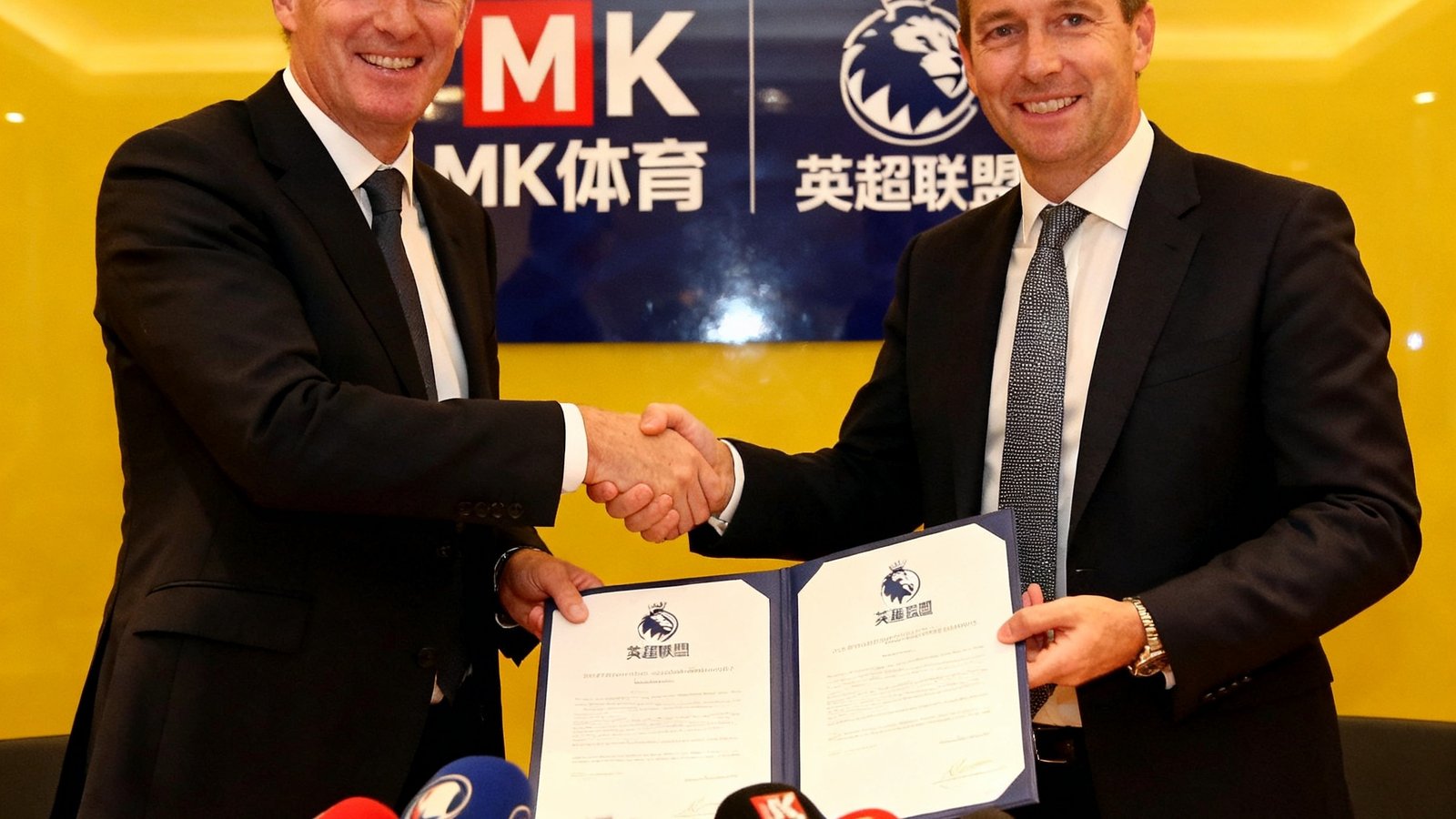 MK体育与英超联盟独家新媒体转播协议签约仪式，双方代表在媒体镜头前握手并交换正式合同文本
